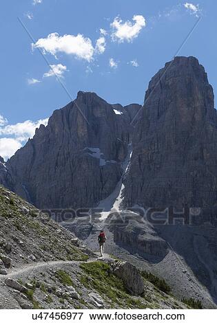 Stock Photo - Climber approaching rocky peak, Brenta Dolomites, Italy. Fotosearch