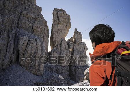 Stock Image - Climber looking at rocky walls, Brenta Dolomites, Italy. Fotosearch