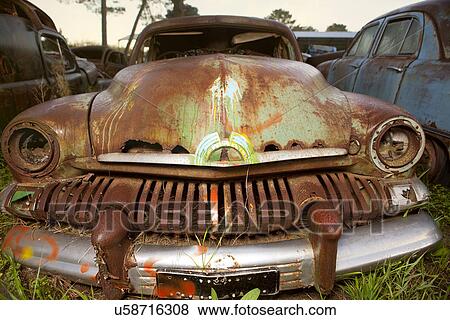Stock Photo - Close up of vintage car in scrap yard. Fotosearch