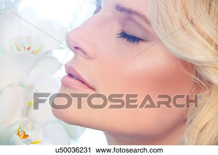 Close up of woman smelling orchids View Large Photo Image Stock Image - Close up of woman smelling orchids. Fotosearch