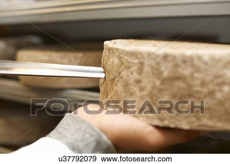 Stock Photo - Close up of worker examining cheese round at farm factory. Fotosearch