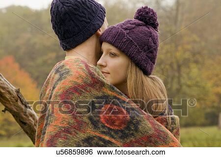 Close up of young couple wrapped in blanket in misty park View Large Photo Image Stock Photograph - Close up of young couple wrapped in blanket in misty park. Fotosearch