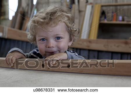 Close up portrait of male toddler inside boat in workshop View Large Photo Image Stock Image - Close up portrait of male toddler inside boat in workshop. Fotosearch