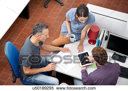 Stock Photography - Colleagues working in office, high angle. Fotosearch