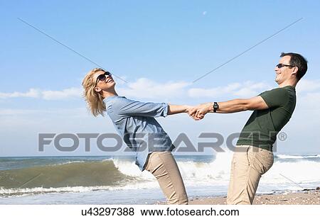 Stock Photo - Couple enjoying vacation on beach. Fotosearch
