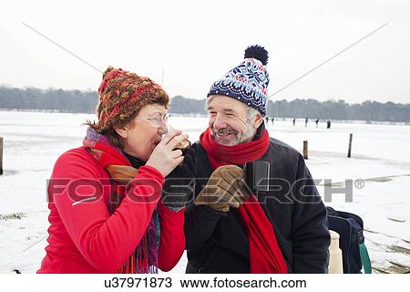 Couple having hot drink in snow View Large Photo Image Stock Image - Couple having hot drink in snow. Fotosearch