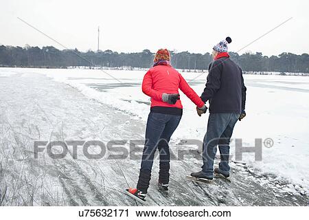 Couple ice skating, holding hands View Large Photo Image Stock Image - Couple ice skating, holding hands. Fotosearch