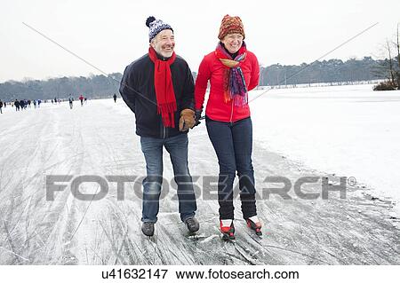 Couple ice skating, holding hands View Large Photo Image Stock Photo - Couple ice skating, holding hands. Fotosearch