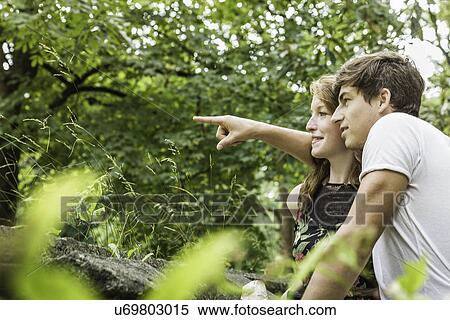Stock Photography - Couple in park, pointing finger. Fotosearch