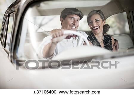 Couple in vintage car View Large Photo Image Stock Image - Couple in vintage car. Fotosearch
