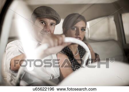 Stock Photograph - Couple in vintage car. Fotosearch