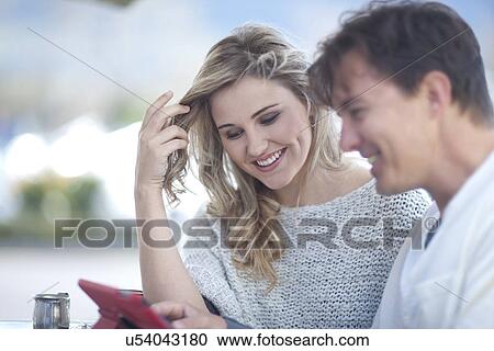 Couple looking at digital tablet View Large Photo Image Stock Image - Couple looking at digital tablet. Fotosearch