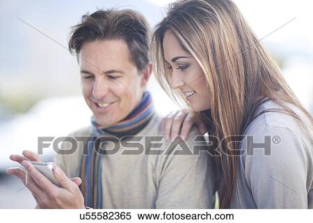 Stock Photography - Couple looking at smartphone. Fotosearch