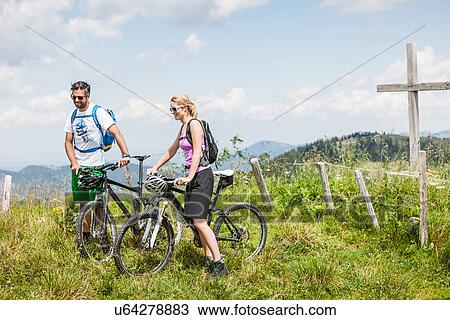 Stock Image - Couple on mountain bikes, Tyrol, Austria. Fotosearch