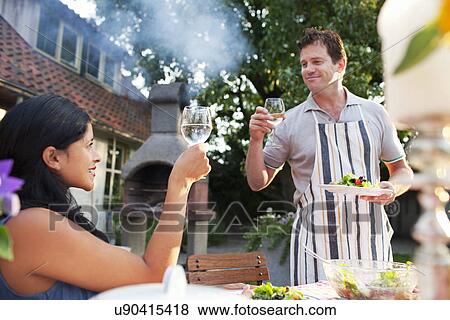 Couple raising toast with glass of water View Large Photo Image Stock Photo - Couple raising toast with glass of water. Fotosearch