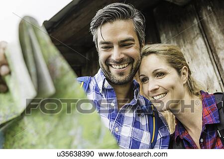 Couple smiling at map View Large Photo Image Stock Image - Couple smiling at map. Fotosearch