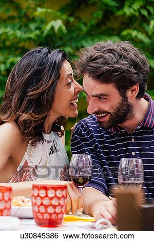 Couple whispering at outdoor meal View Large Photo Image Stock Photograph - Couple whispering at outdoor meal. Fotosearch