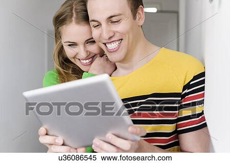 Couple with digital tablet, smiling View Large Photo Image Stock Photography - Couple with digital tablet, smiling. Fotosearch