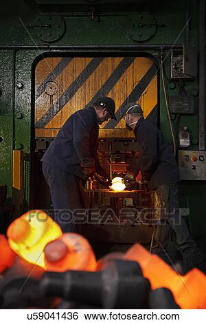 Stock Photograph - Crank shaft is inserted into clipping press to remove excess "flash". Fotosearch