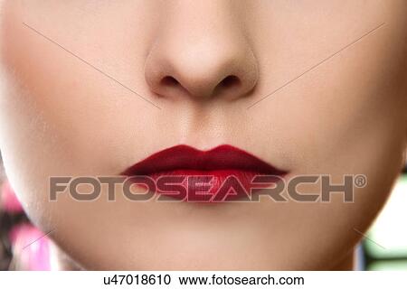 Stock Image - Cropped studio portrait of young woman's lips. Fotosearch