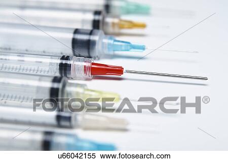 Stock Photography - Disposable plastic medical syringes with attached hypodermic needles. Fotosearch