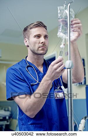 Doctor adjusting intravenous drip in hospital View Large Photo Image Stock Image - Doctor adjusting intravenous drip in hospital. Fotosearch