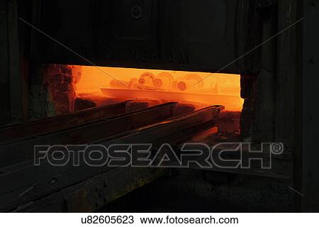 Stock Image - Drive shafts on trays in heat treatment furnace. Fotosearch