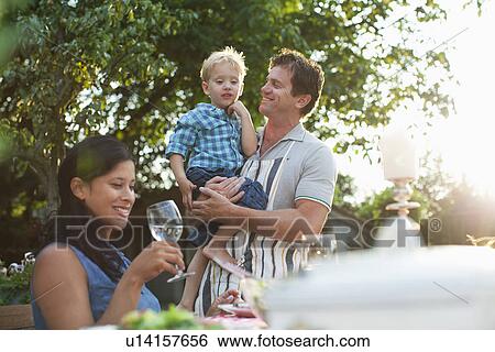 Stock Photograph - Family having dinner in garden. Fotosearch