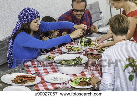 Stock Photo - Family sitting down to picnic lunch, Tyrol, Austria. Fotosearch
