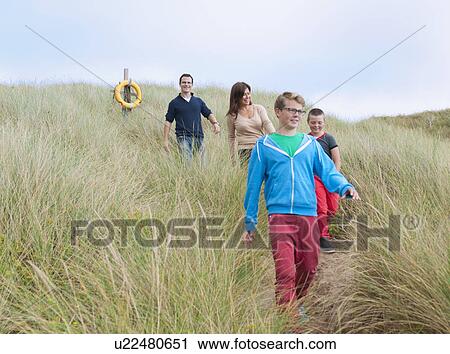 Stock Image - Family strolling coastal path. Fotosearch