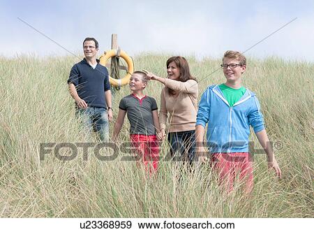 Family strolling in sand dunes View Large Photo Image Stock Photo - Family strolling in sand dunes. Fotosearch