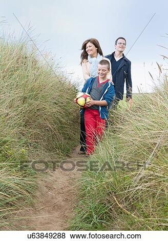 Stock Photo - Family walking in sand dunes. Fotosearch