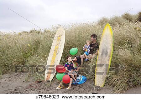 Stock Photo - Family with two boys on beach with surfboards. Fotosearch