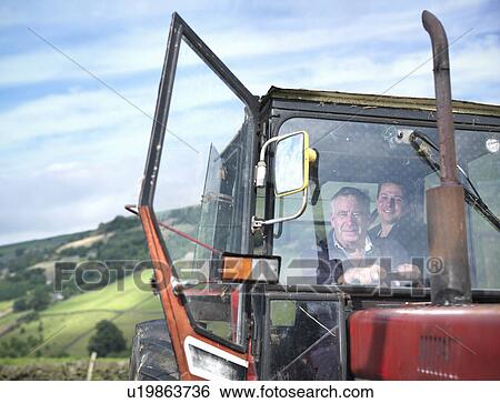 Stock Photograph - Farmer and son in tractor cab, portrait. Fotosearch