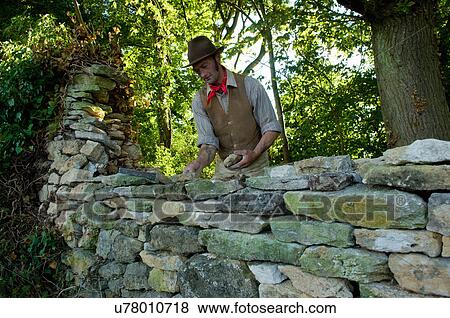 Stock Photo - Farmer repairing dry stone wall. Fotosearch