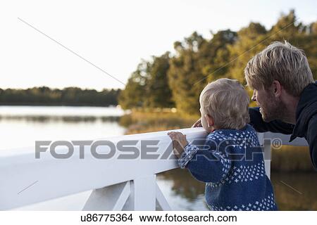 Father and son looking at lake View Large Photo Image Picture - Father and son looking at lake. Fotosearch