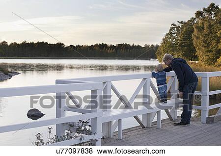 Father and son looking at lake View Large Photo Image Stock Photo - Father and son looking at lake. Fotosearch