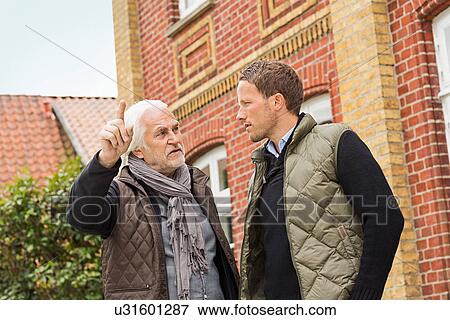 Father and son outside building, senior man pointing View Large Photo Image Stock Photo - Father and son outside building, senior man pointing. Fotosearch