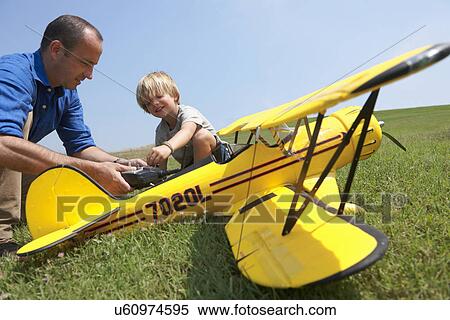 Stock Photography - Father and son preparing model plane. Fotosearch