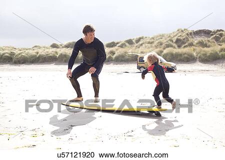 Father and son with surfboard on beach View Large Photo Image Stock Image - Father and son with surfboard on beach. Fotosearch