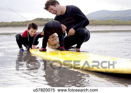 Father and sons playing with surfboard View Large Photo Image Stock Photography - Father and sons playing with surfboard. Fotosearch
