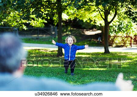 Father and toddler playing in park View Large Photo Image Stock Photograph - Father and toddler playing in park. Fotosearch