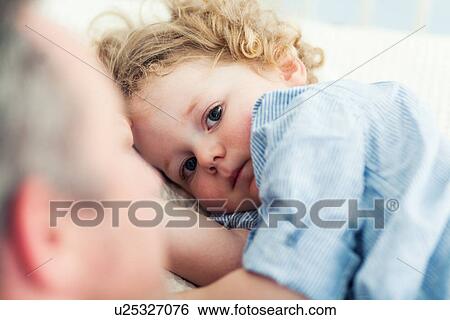 Stock Photograph - Father and toddler son at bedtime. Fotosearch
