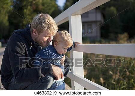 Father and toddler son looking through railing View Large Photo Image Stock Photo - Father and toddler son looking through railing. Fotosearch