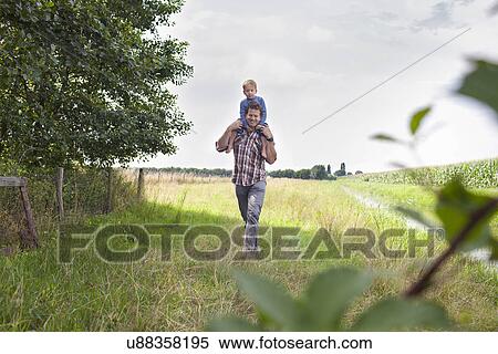 Father carrying son on shoulders View Large Photo Image Stock Photography - Father carrying son on shoulders. Fotosearch