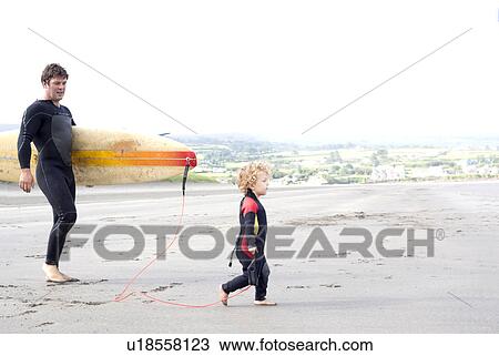 Father carrying surfboard with son on beach View Large Photo Image Stock Image - Father carrying surfboard with son on beach. Fotosearch