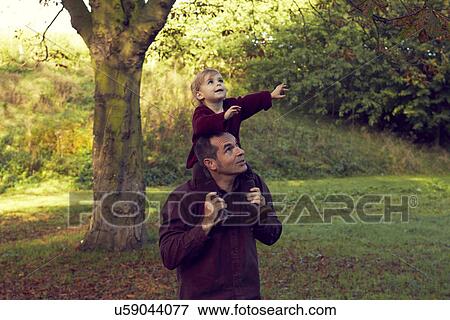 Stock Photo - Father carrying toddler on shoulders. Fotosearch