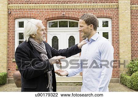 Father giving son key outside house View Large Photo Image Stock Image - Father giving son key outside house. Fotosearch