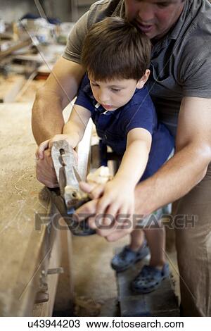 Father mentoring son on carpentry in boat workshop View Large Photo Image Stock Image - Father mentoring son on carpentry in boat workshop. Fotosearch