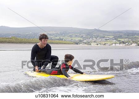 Father teaching son how to surf View Large Photo Image Picture - Father teaching son how to surf. Fotosearch